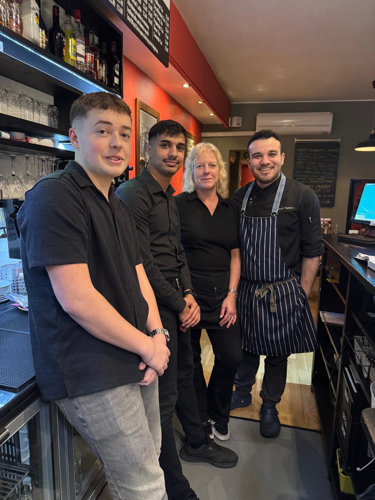 Mikail with the front-of-house team at the bar