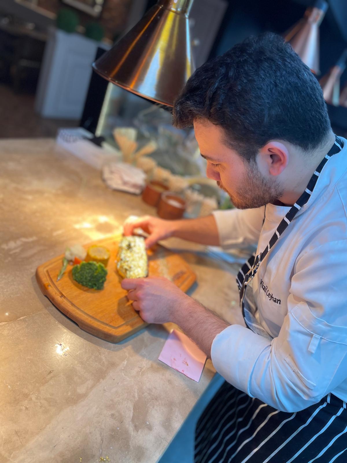 Mikail plating a gold-leaf steak at the counter