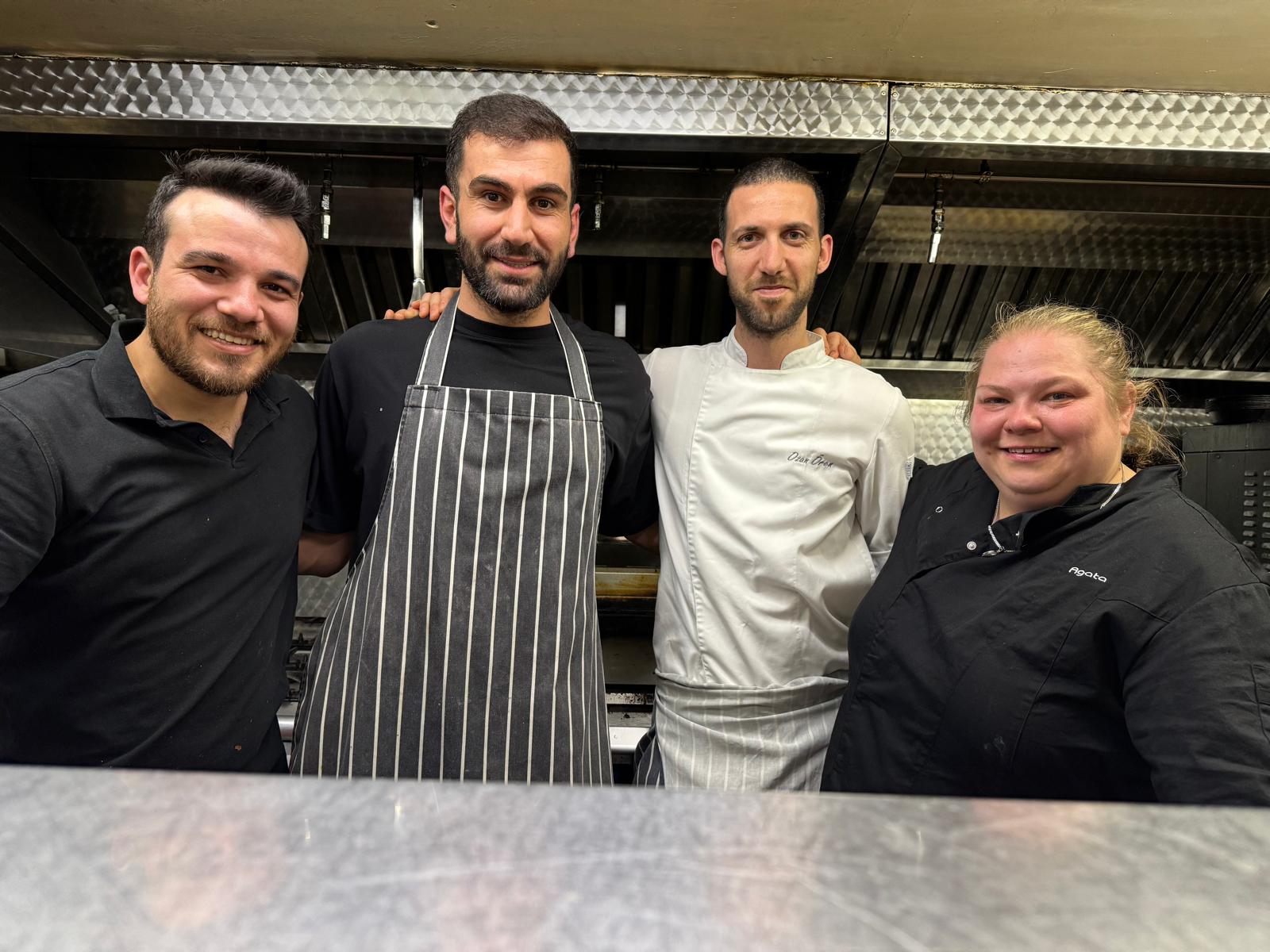 Mikail with three chefs behind the pass